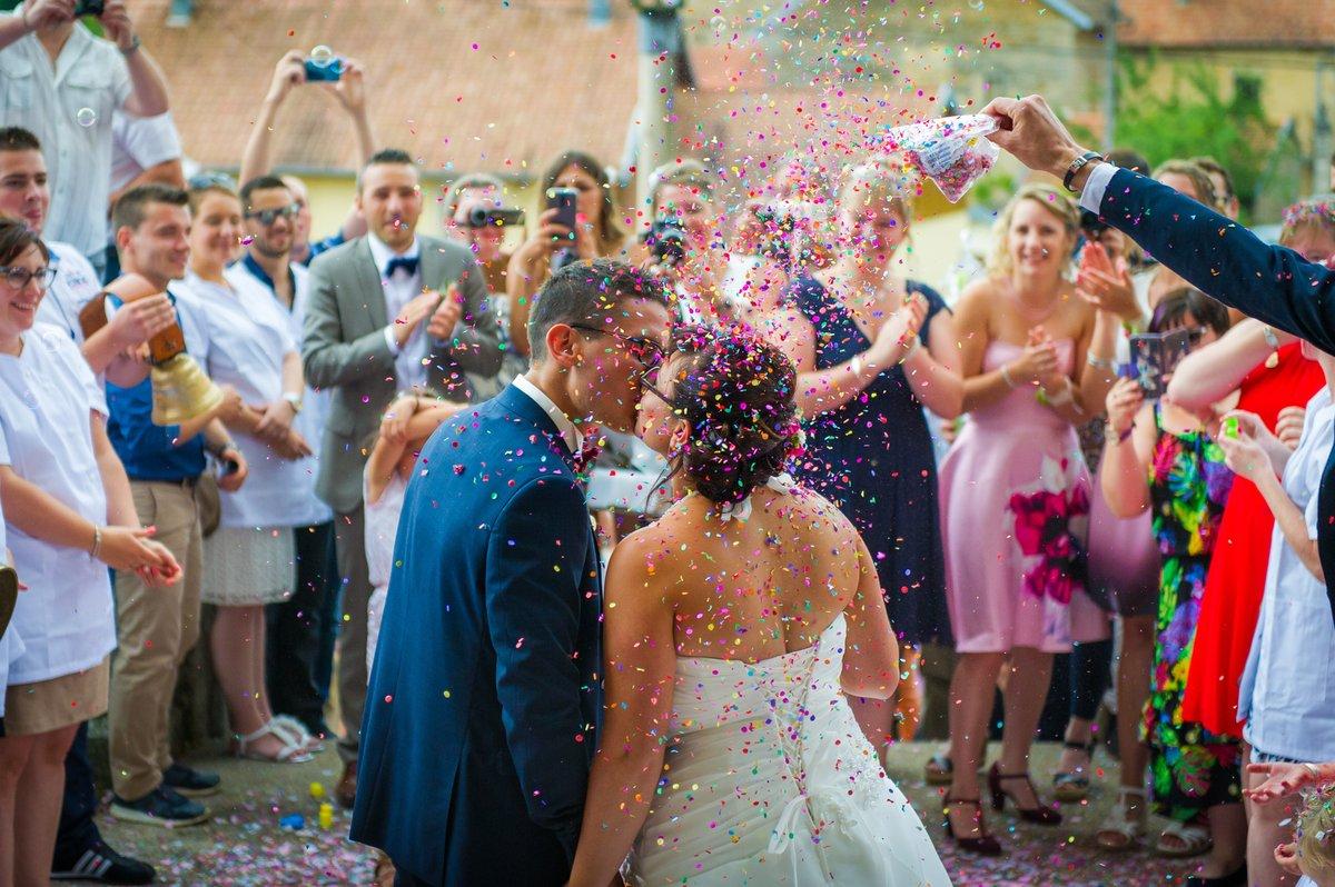 Mariés s'embrassant sous une pluie de confettis