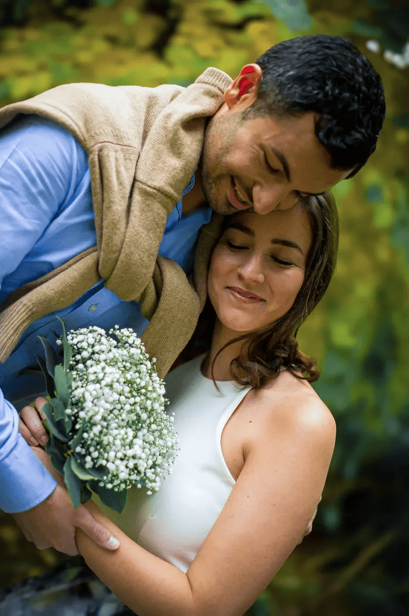 Futurs mariés enlacés avec un bouquet de fleurs lors d'une love session
