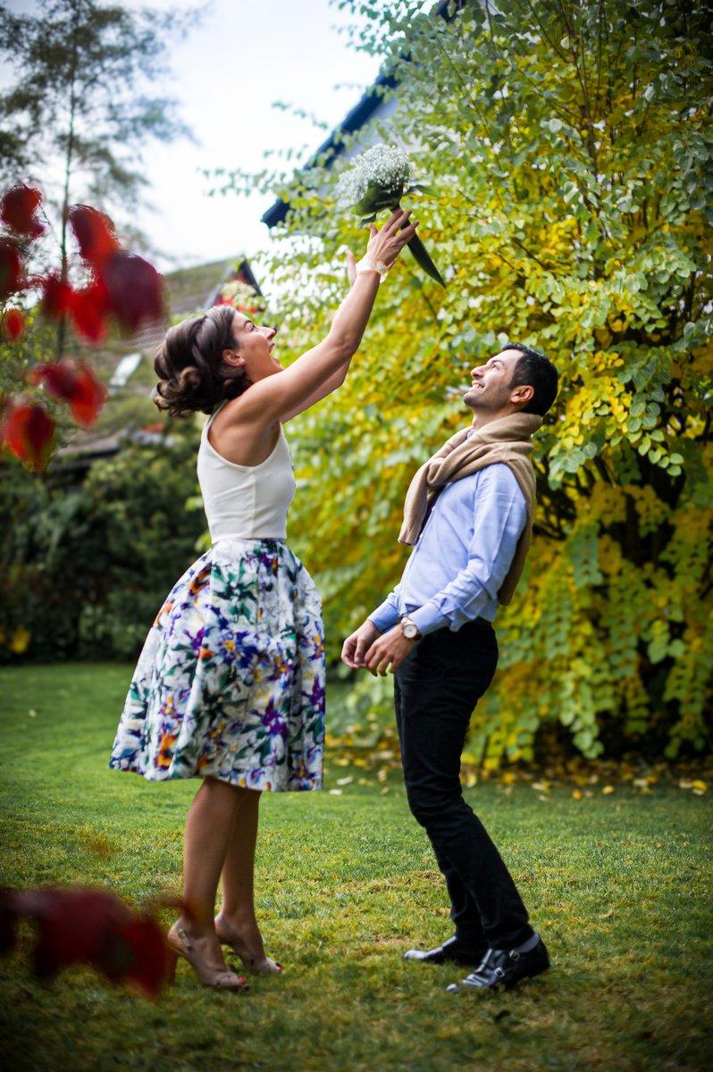 Les futurs mariés s'amusent dans le jardin avec un bouquet
