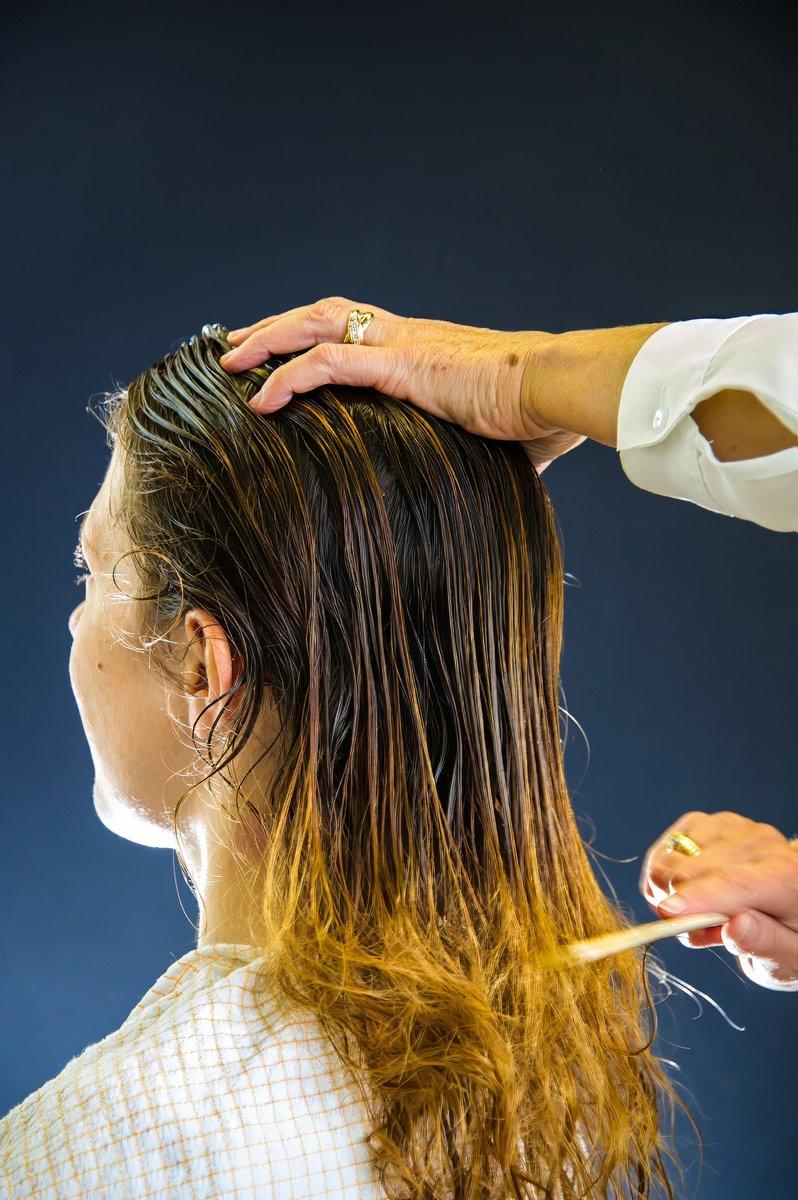 Coiffeuse peignant les cheveux mouillés de la mariée
