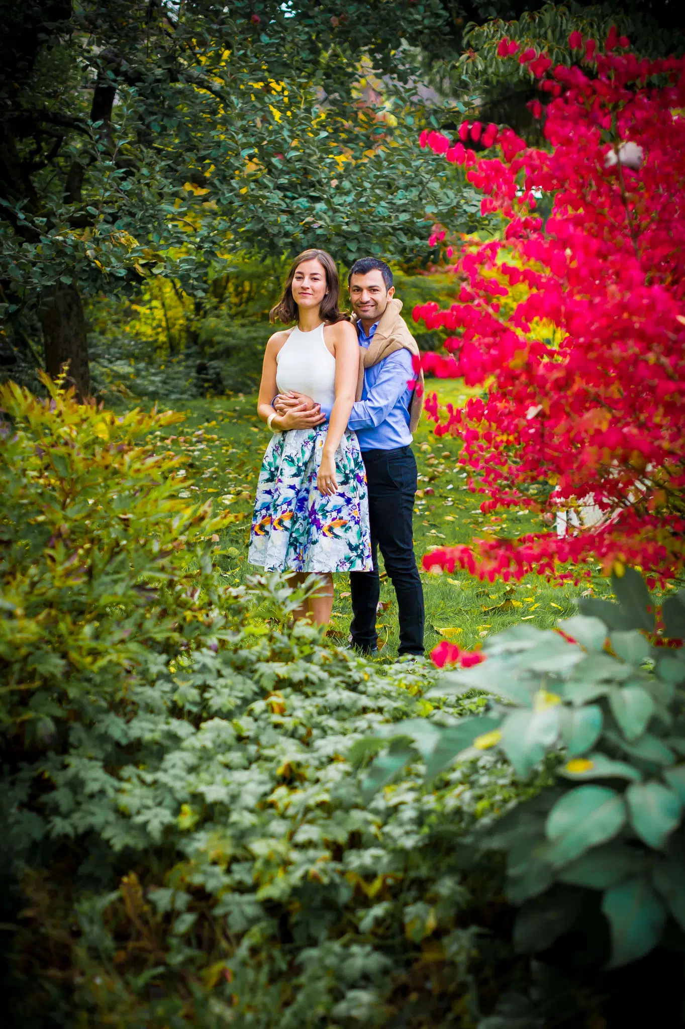 Futurs mariés dans le jardin entourés de fleurs