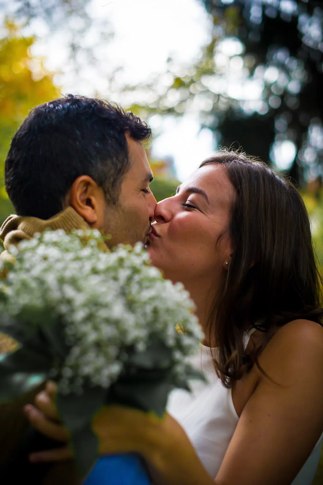 Futurs mariés qui s'embrassent avec un bouquet de fleurs