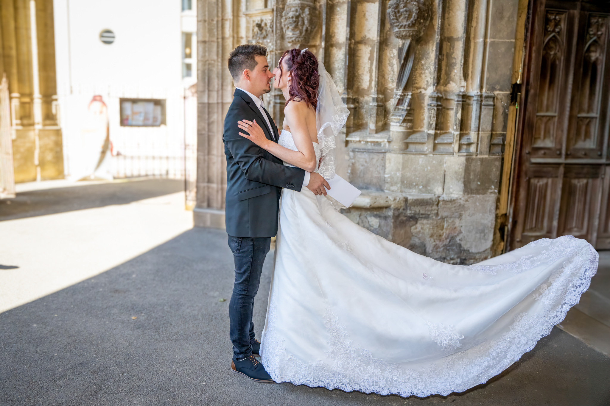 Marié et mariée échangeant un regard tendre, robe à traîne