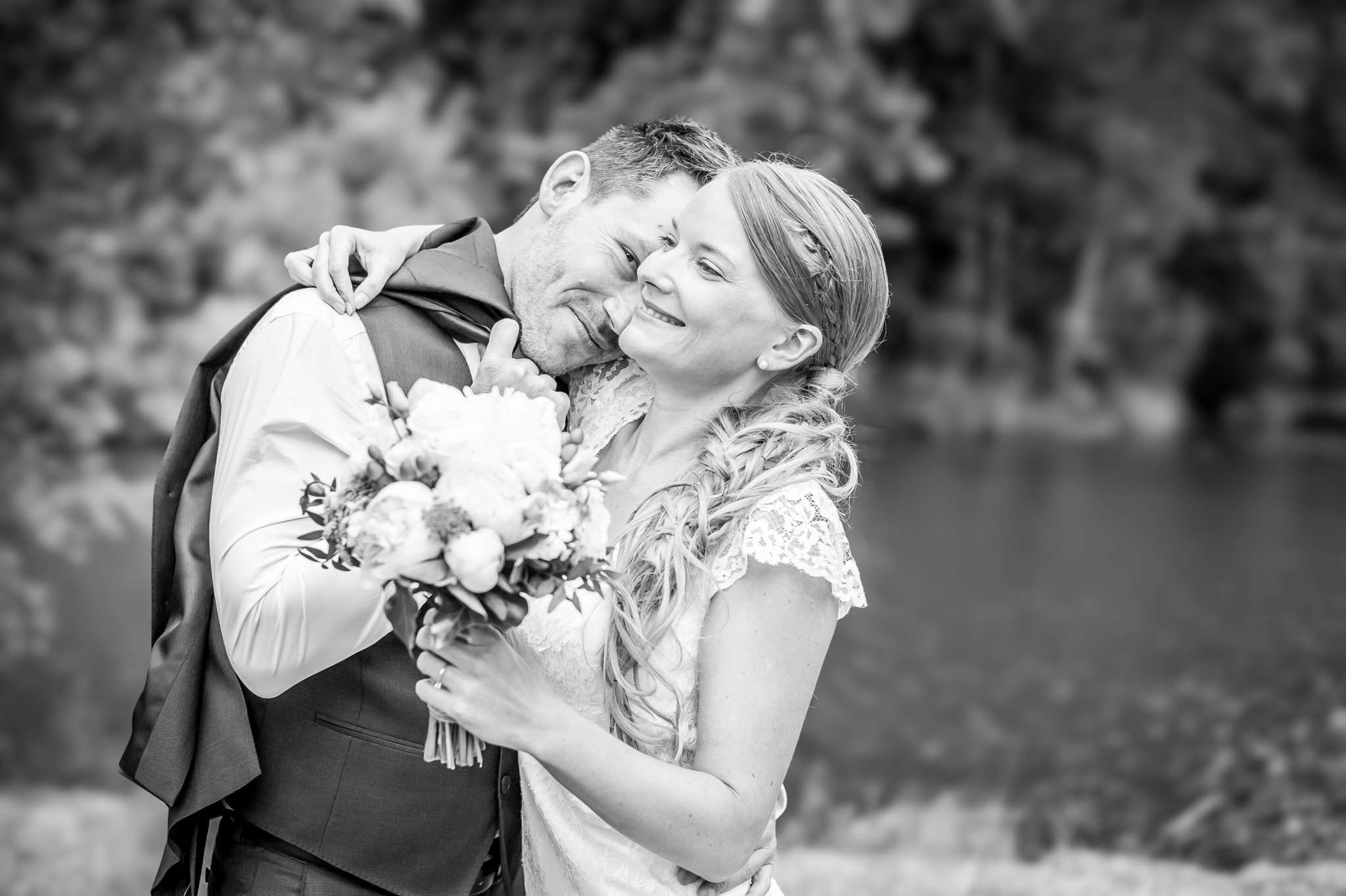 Mariés s'enlaçant avec un bouquet
