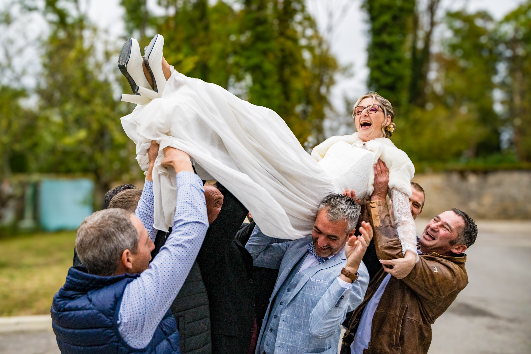 Invités portant la mariée en l'air pendant les célébrations