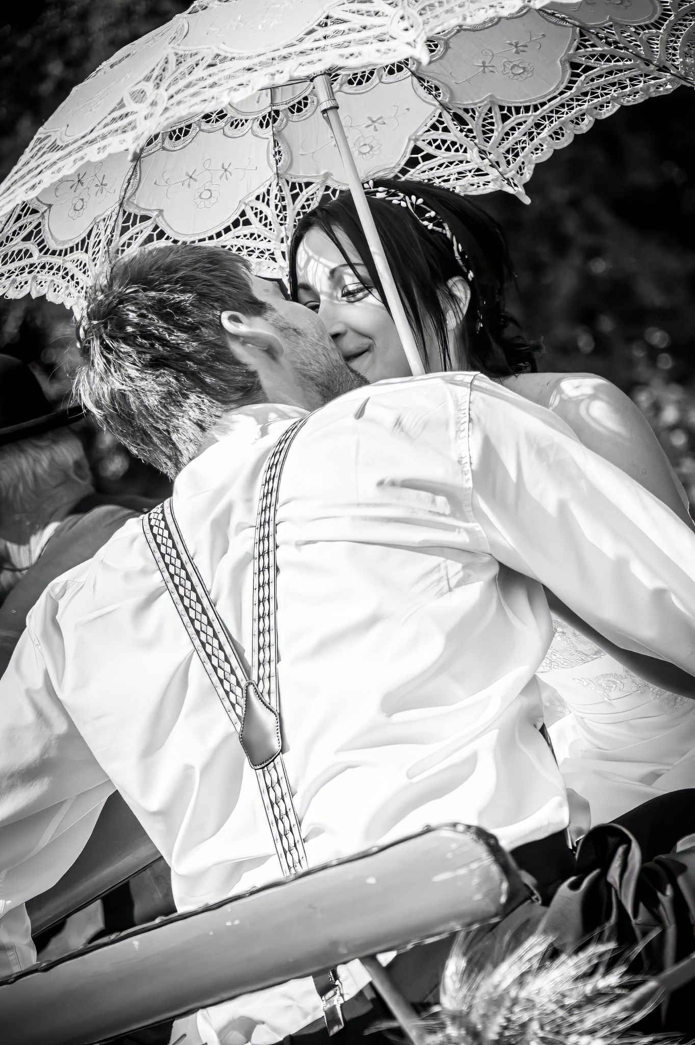 Mariés s'embrassant sous une ombrelle