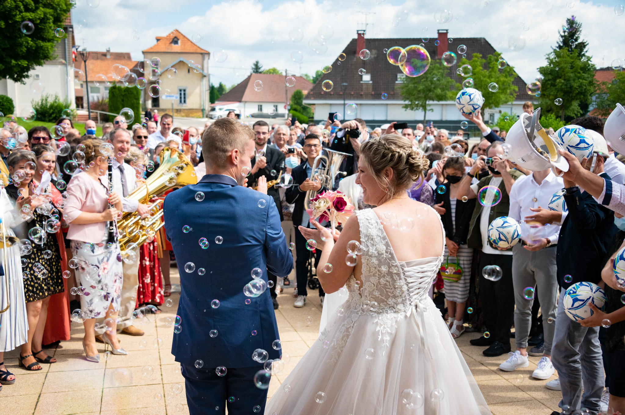 Mariés sortant de l'église avec des bulles, vue de dos