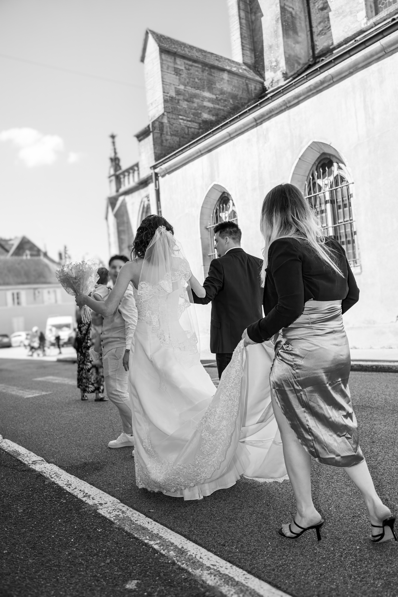 Témoin tenant la robe de la mariée pour l'aider