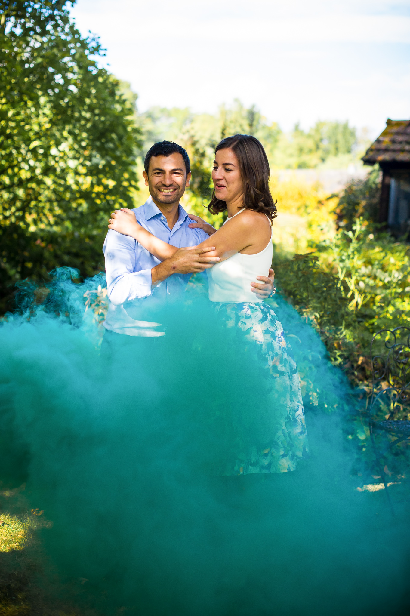 Les futurs mariés dansent dans une fumée verte dans le jardin