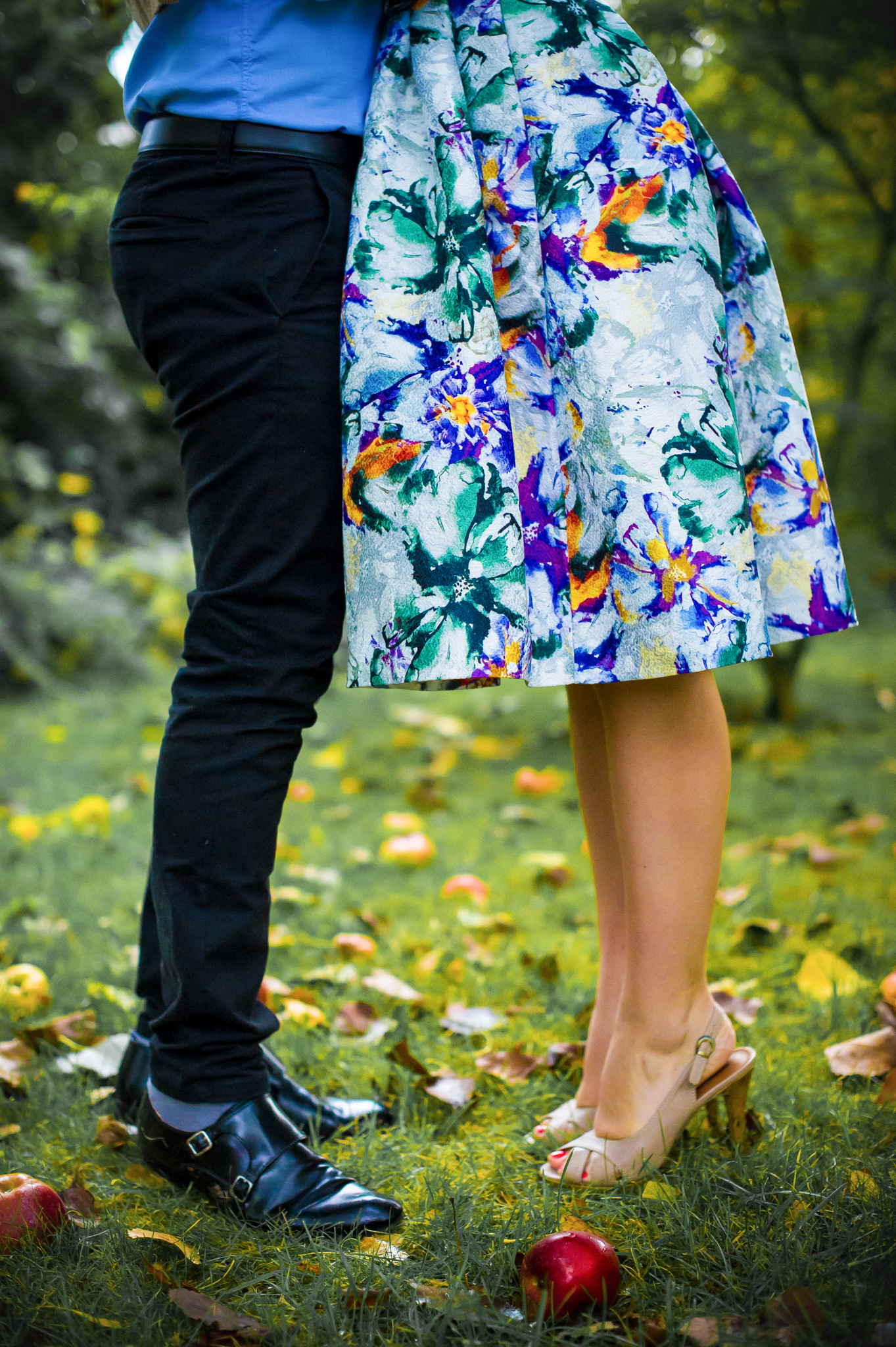 Les jambes des futurs mariés dans le jardin avec des pommes par terre