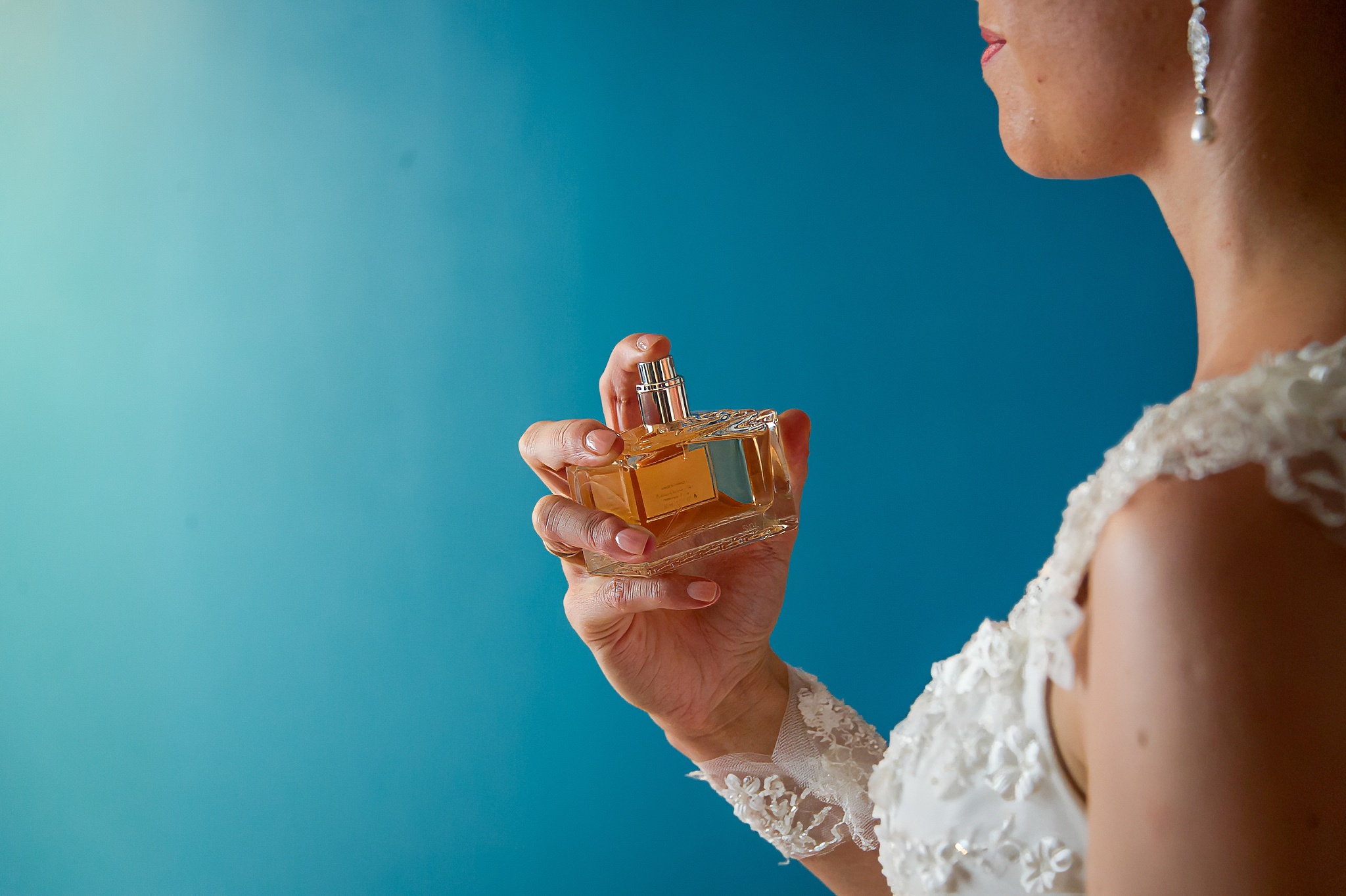 La mariée en robe appliquant du parfum