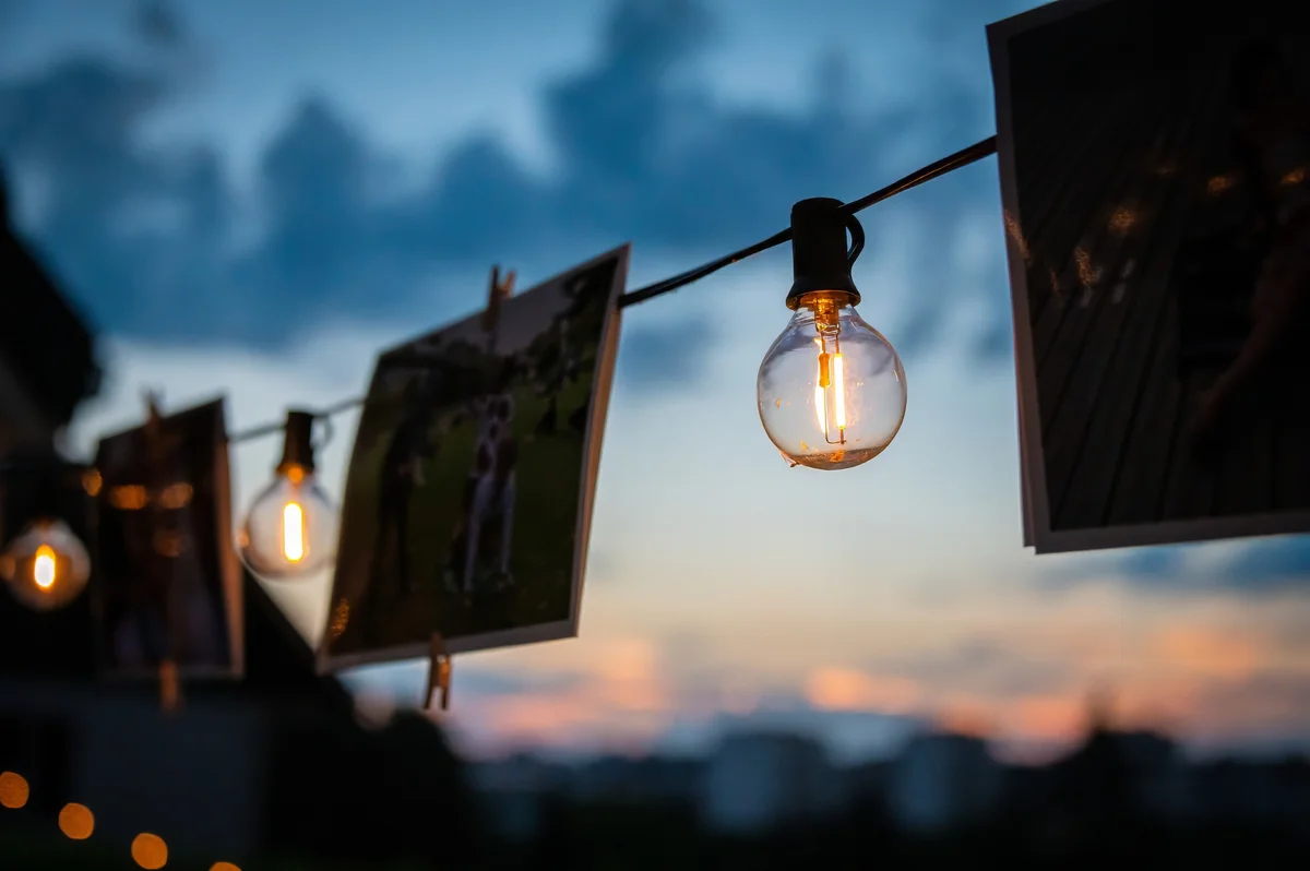 Des photos accrochées avec des lampes illuminées au coucher du soleil