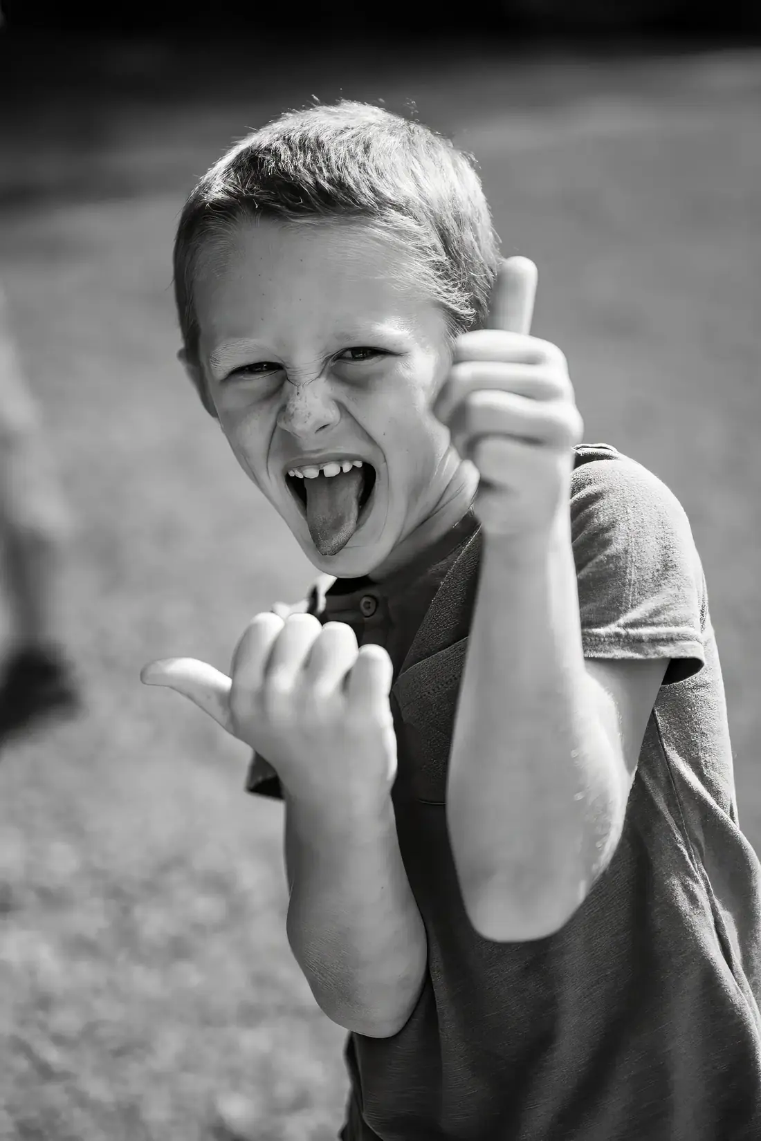 Enfant faisant des grimaces amusantes avec les mains et tirant la langue