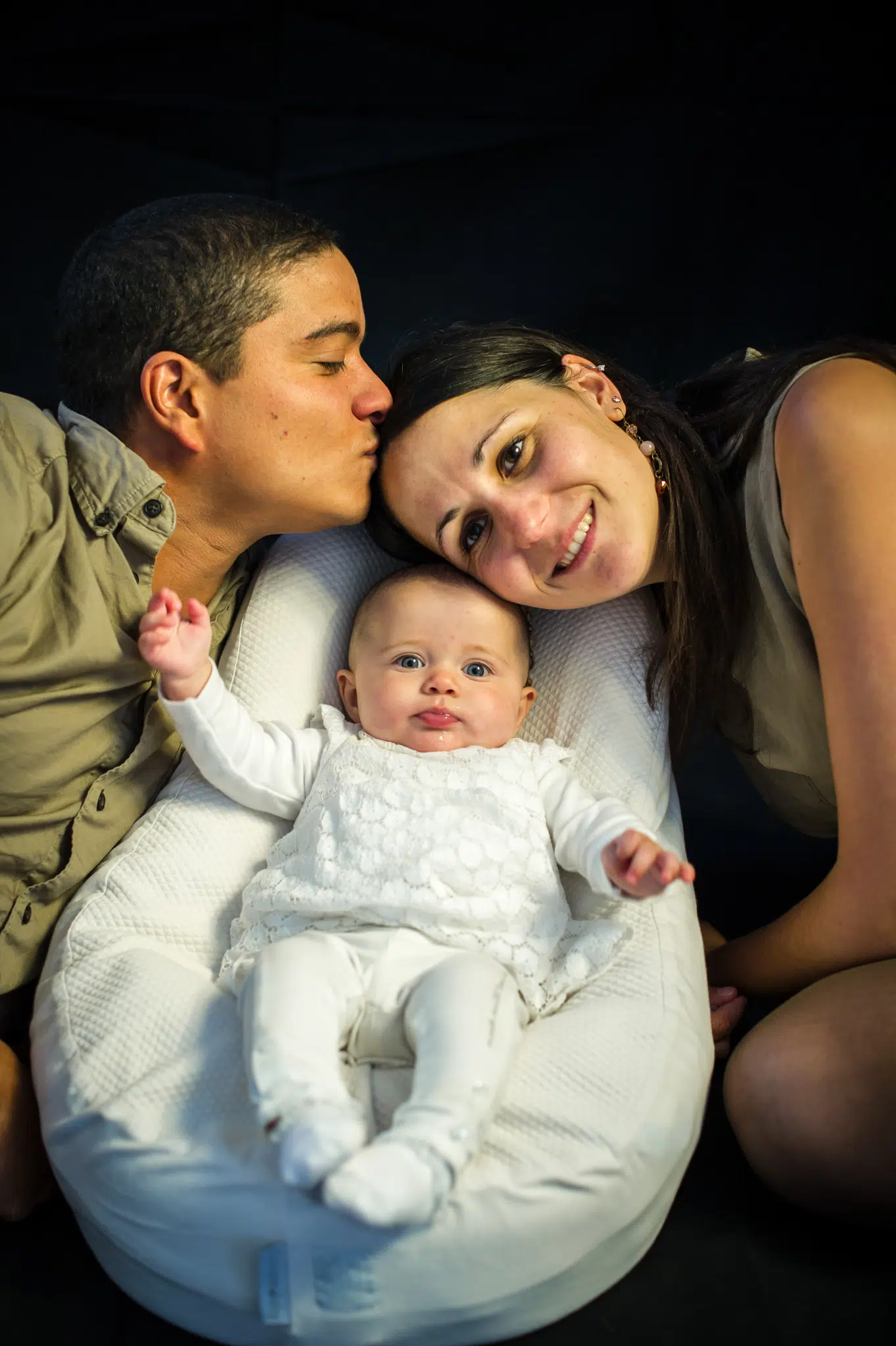 Le papa et la maman sourient avec leur bébé dans un cocon