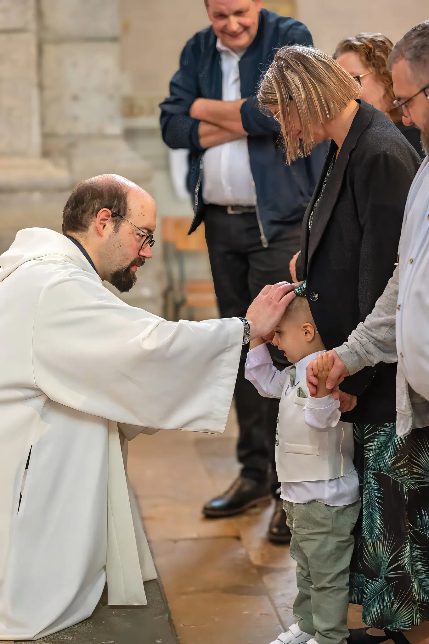 Le prêtre bénit un enfant pendant la cérémonie du baptême