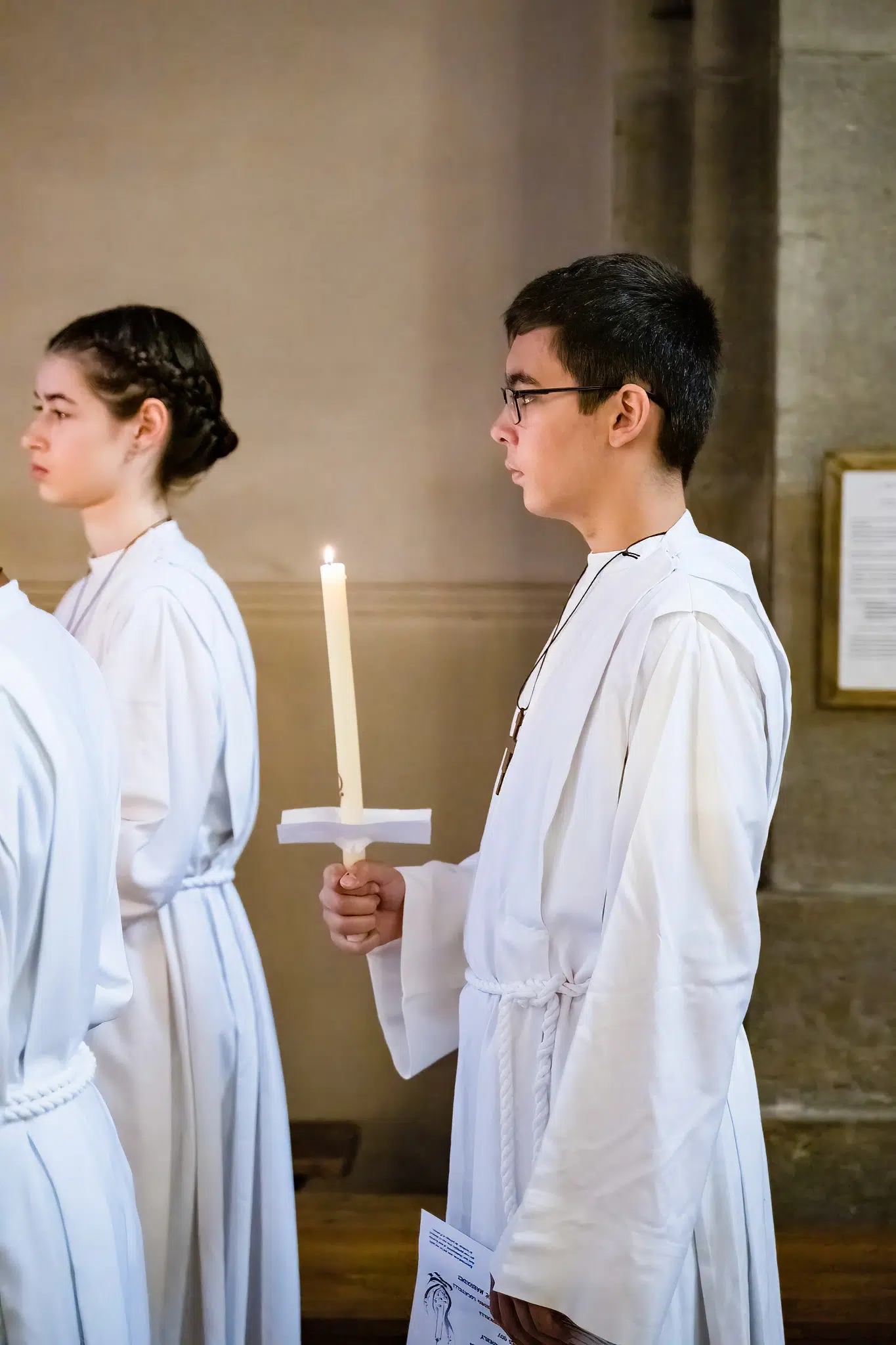 Un enfant tient une bougie allumée pendant la cérémonie