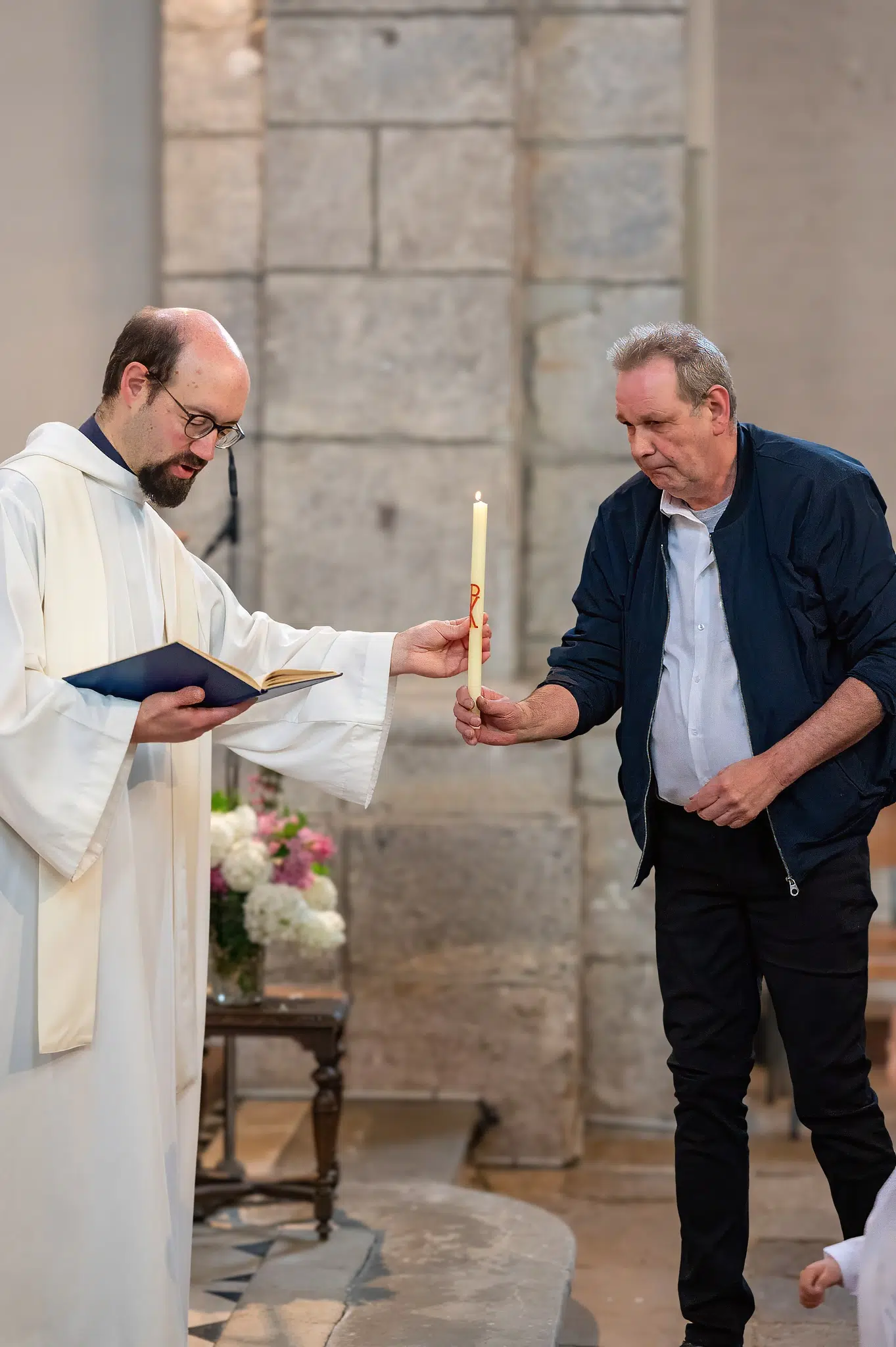 Un homme reçoit une bougie du prêtre pendant la cérémonie