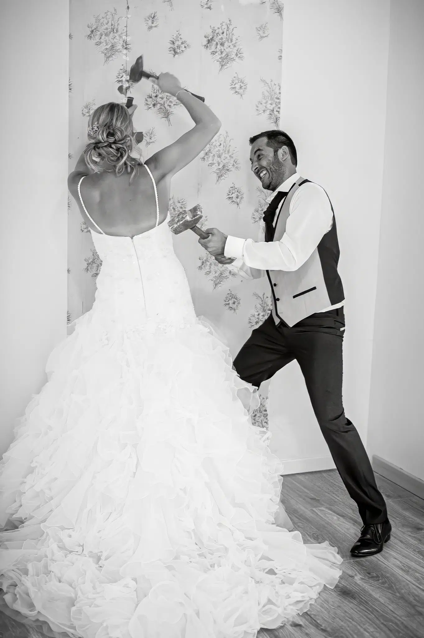 Mariés cassant un mur ensemble avec des marteaux – Trash the Dress