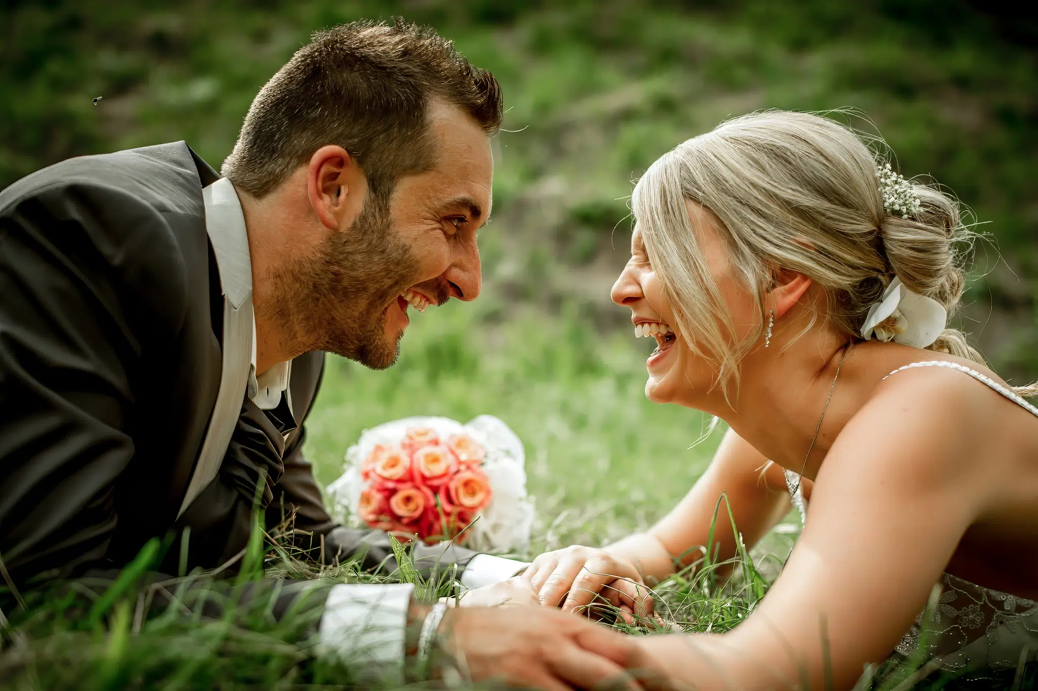 Mariés riant allongés dans l'herbe – Trash the Dress